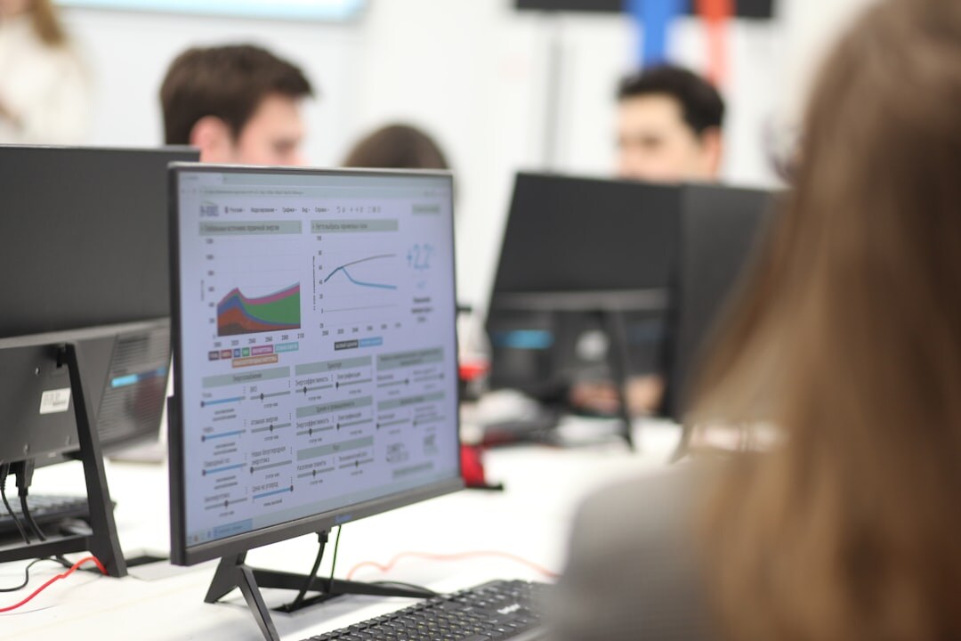 Diverse team of journalists working together at computer screens in a modern newsroom